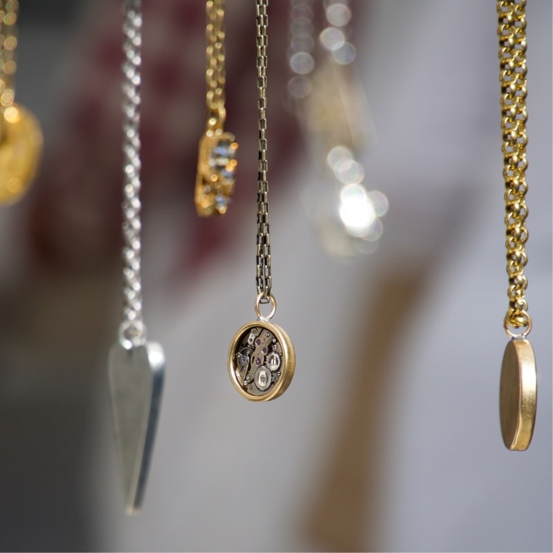 Dangling gold and silver chains on blurred background